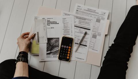 Financial newspaper showing tax and financial headlines – personal tax filing for individuals, W-2, 1099, and family tax planning.